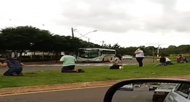 Pessoas movidas pela fé se ajoelham e realizam orações em frente ao Hospital de Campanha em Patos de Minas 