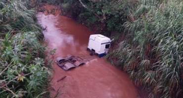 Caminhão trator cai dentro do Córrego Mata-Burro na BR-354 e deixa motorista e passageiro feridos 