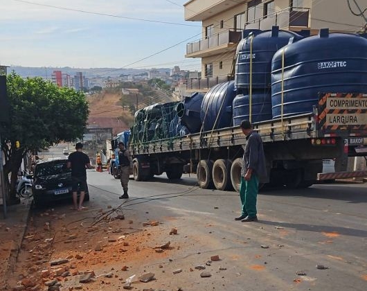 Caminhão transportando caixas d'água arrasta fios e derruba parede de comercio no centro de Patos de Minas